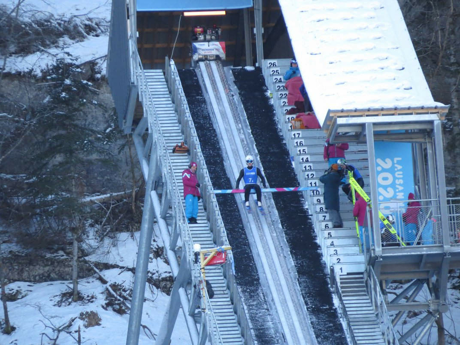 Ski Jumper Flying Sitting at Top of Run Ramp